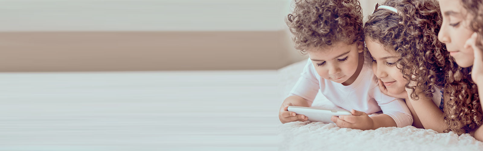 Three children looking at a mobile phone