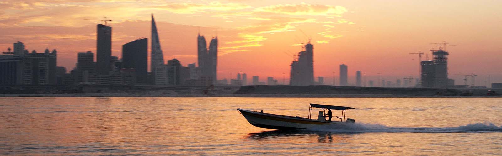 Boat sailing at sunset. Dubai skyline in the background