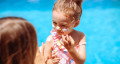 mother helping child dab on sunblock 767x418